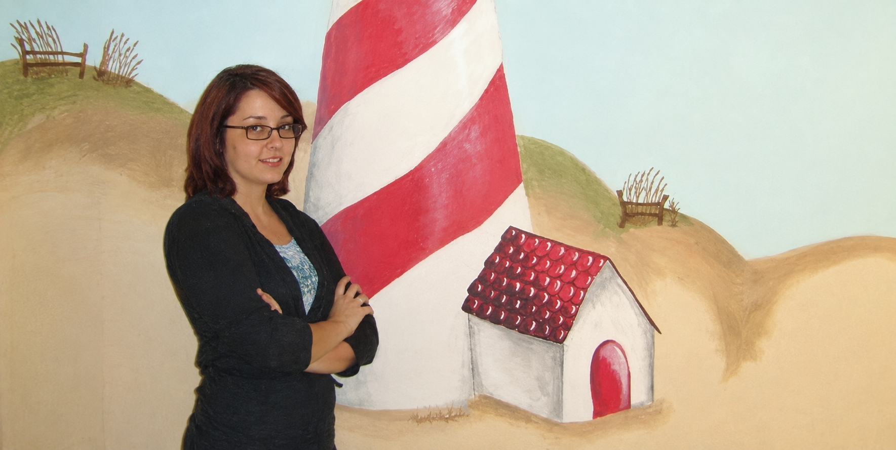 Michelle Hoyt standing beside one of her first murals in 2008